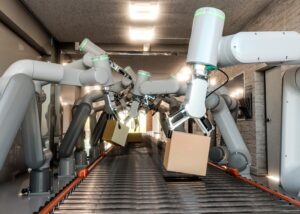A futuristic assembly line featuring robotic arms picking up cardboard boxes from a conveyor belt in a modern warehouse setting.