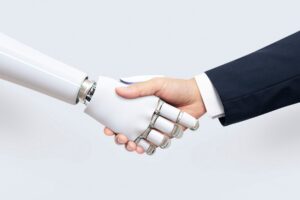 A human hand shakes a sleek, white robotic hand, symbolizing collaboration between technology and humanity.