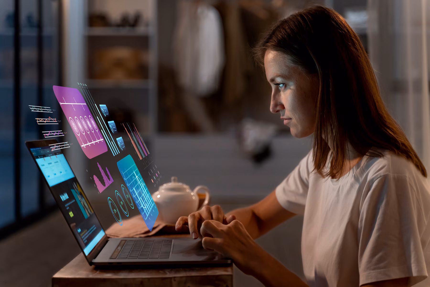 A person sits at a desk using a laptop, surrounded by holographic data visualizations and a teapot in a cozy room.