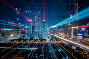 Smart city skyline at night with illuminated buildings and dynamic light trails from traffic , creating a vibrant urban atmosphere.
