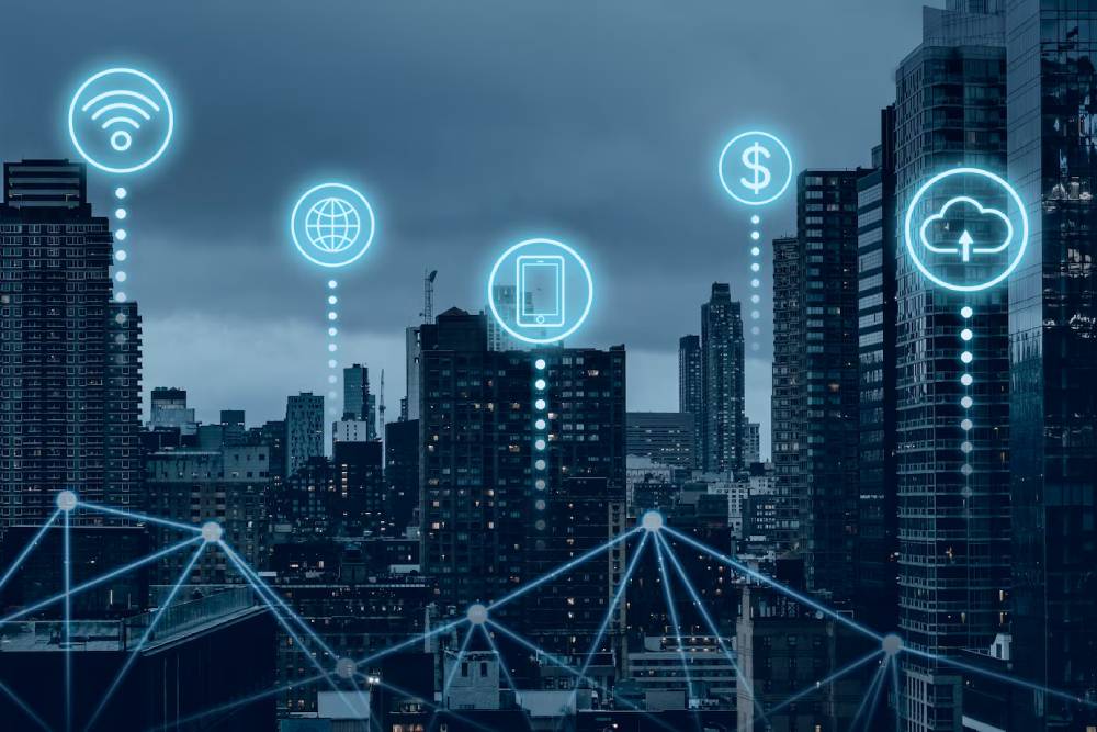 A smart city  with digital icons representing Wi-Fi, the globe, mobile device, currency, and cloud services against a gray sky.