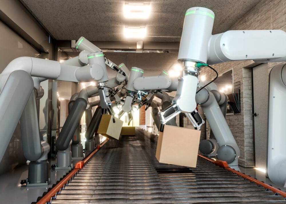 A row of robotic arms with grippers working on a conveyor belt, handling cardboard boxes in a modern automation environment.