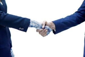 A human and a robotic hand shake, symbolizing collaboration between technology and humanity, against a white background.