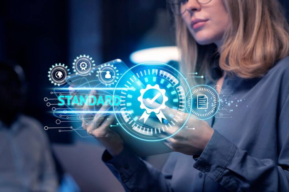 A person is interacting with a holographic display featuring gears and certifications shows the ai in standards development.
